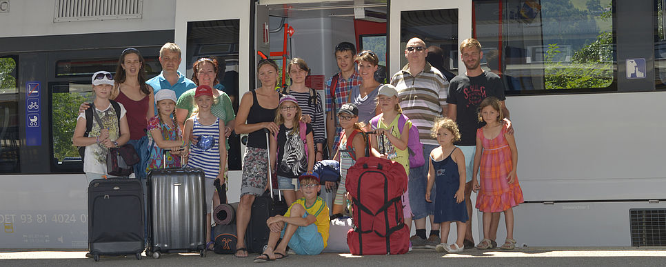 Gruppe mit Kindern und Gruppenleiter/innen vor einer Schnellbahngarnitur